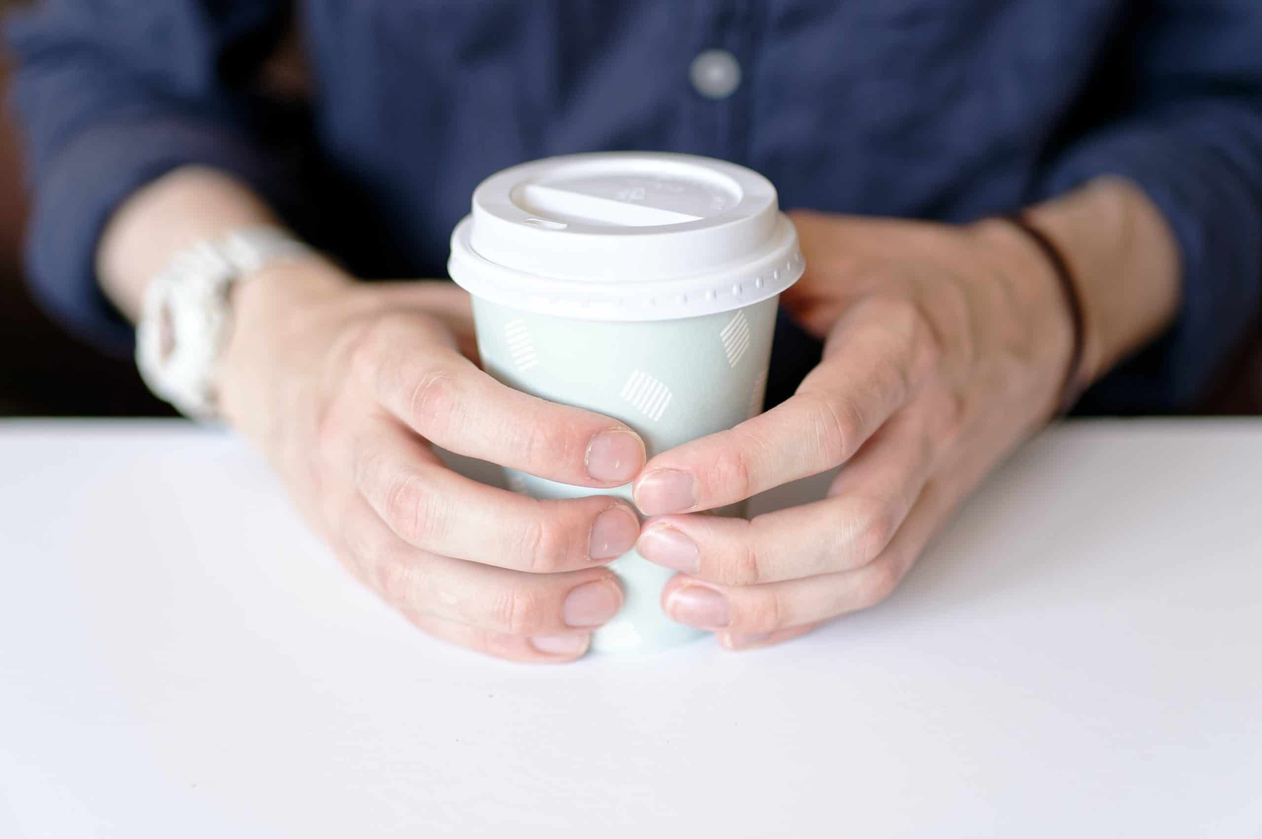 Gobelet en carton entre les mains